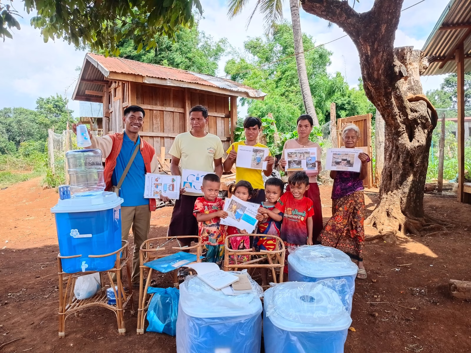 A TerraClear team member and a family celebrate the delivery of new water filters